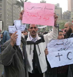 Manifestantes con carteles que dicen: “Cristianos y musulmanes, una sola mano”