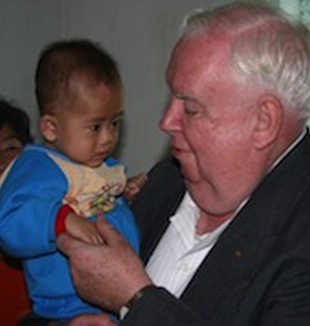 Padre Gerald Hammond con un niño coreano.