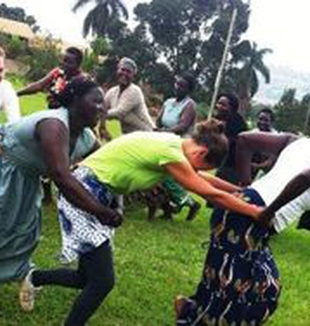 Las dos jóvenes bailando con las mujeres ugandesas.