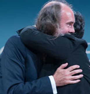 El abrazo de Waters y la presidenta del Meeting.