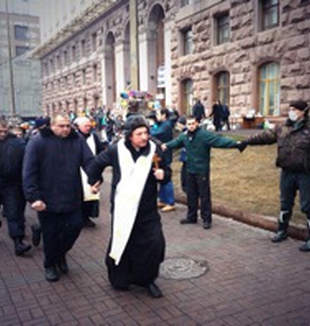 Un sacerdote escolta a un grupo de detenidos <br>por los enfrentamientos en la plaza del Maidan. 