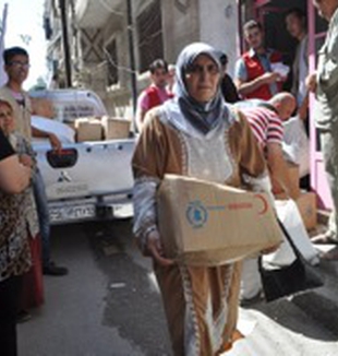 Una mujer siria con una caja de ayuda.