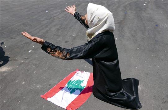 Mujer libanesa ante la bandera de su país (foto Elisa Gestri)